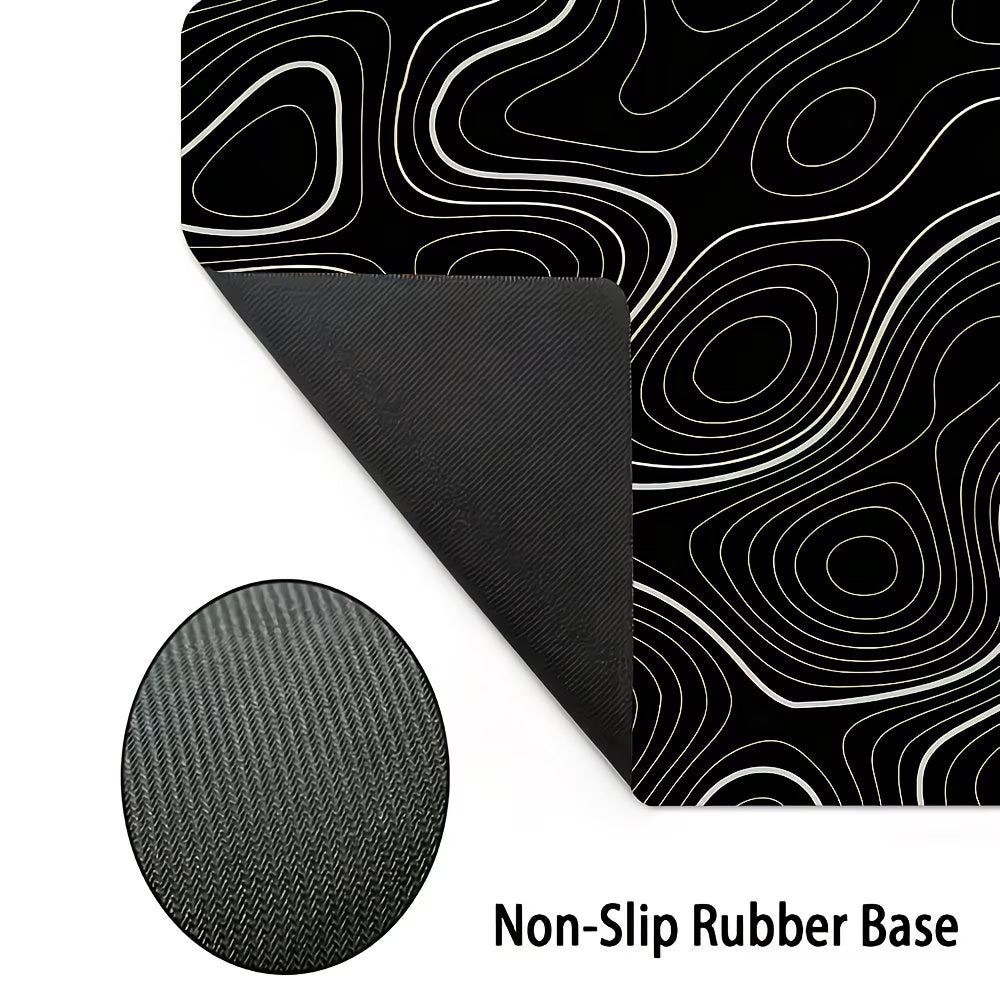 Black and gold wavy patterned mat with non-slip rubber base on a white background